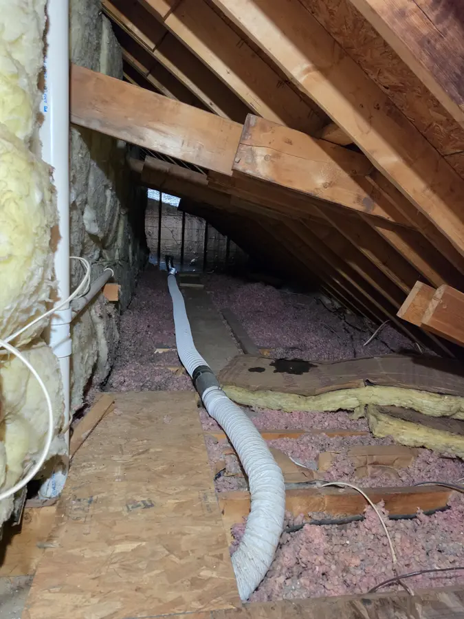 Before: Flexible duct lying across attic insulation