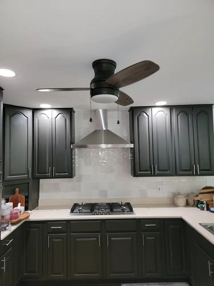 Stainless range hood installed above a gas cooktop